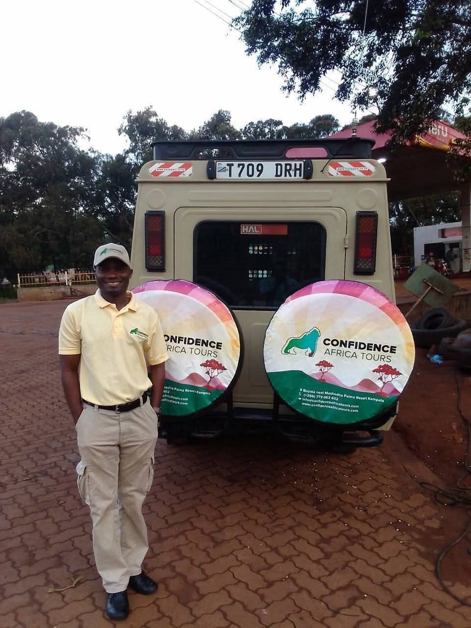 Ein Guide neben einem Safarifahrzeug von Confidence Africa Tours mit tansanischem Kennzeichen