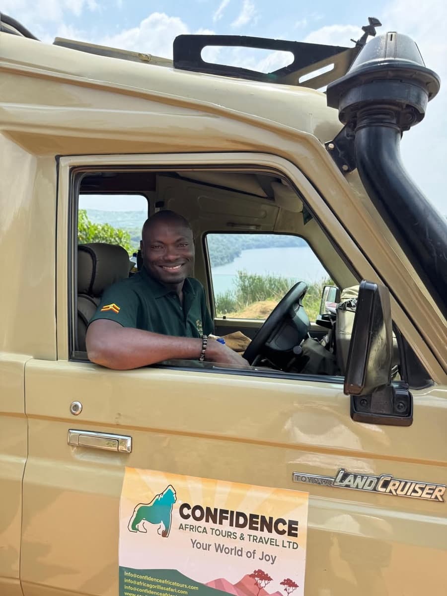 Ein lächelnder Fahrer-Guide am Steuer eines Land Cruisers von Confidence Africa Tours