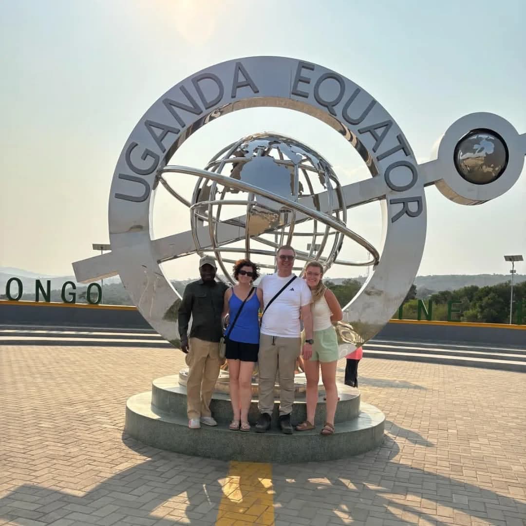 Reisende mit ihrem Guide am Äquator-Denkmal in Uganda